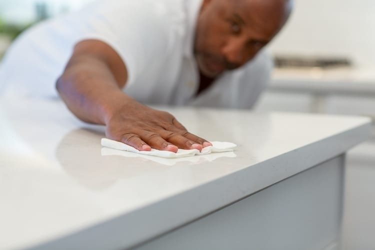 man cleaning his quartz countertop