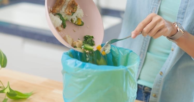 scraping food leftovers into bin