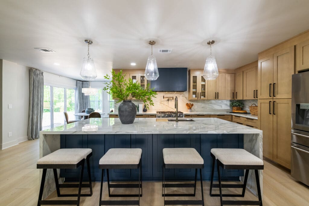 Wide view of modern kitchen with Calacatta Extra porcelain countertops, waterfall island, pendant lighting, and seating.