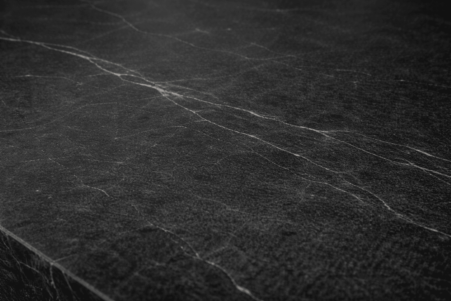 Close-up of dark soapstone countertop with subtle light veining and smooth matte finish